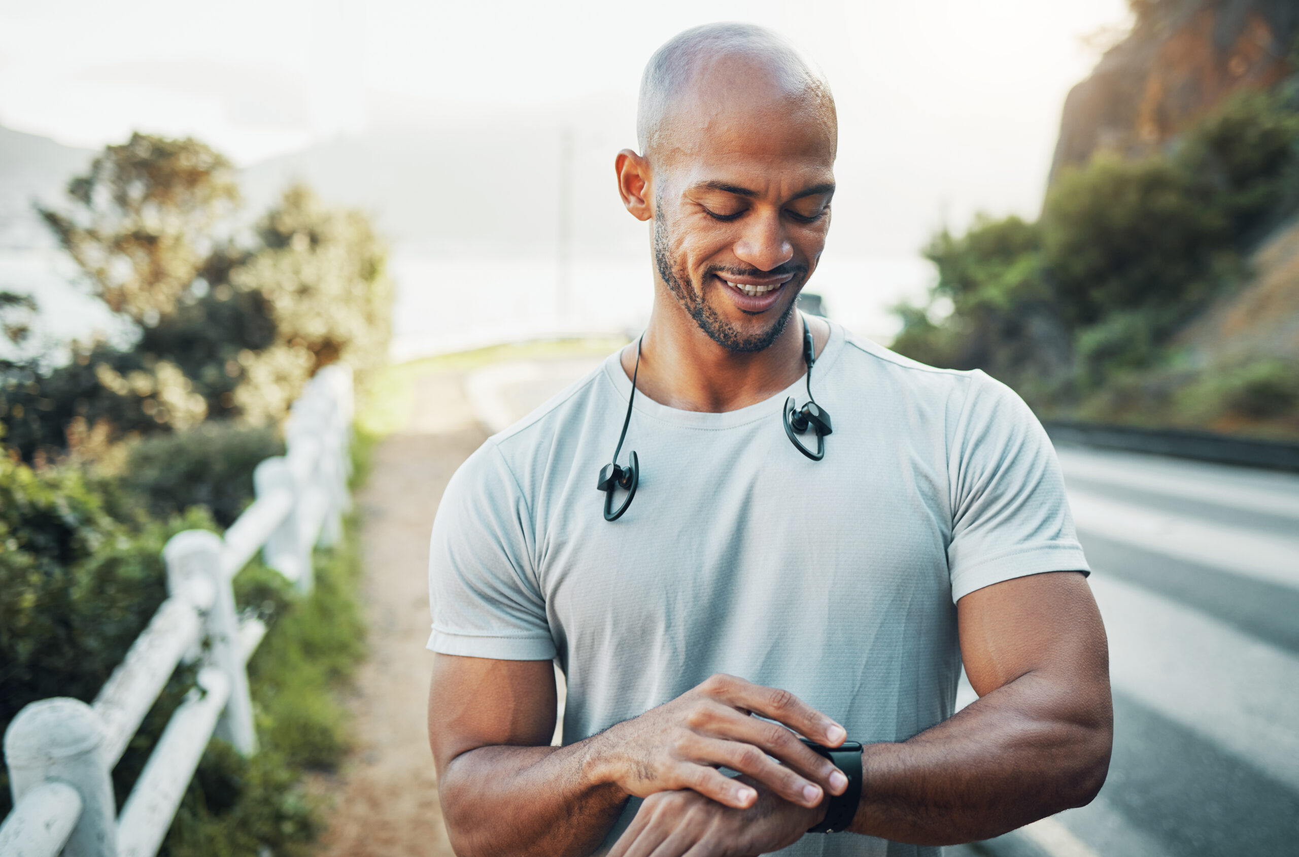 A man checking his pulse using a smartwatch during an outdoor workout, symbolizing health tracking and performance monitoring.